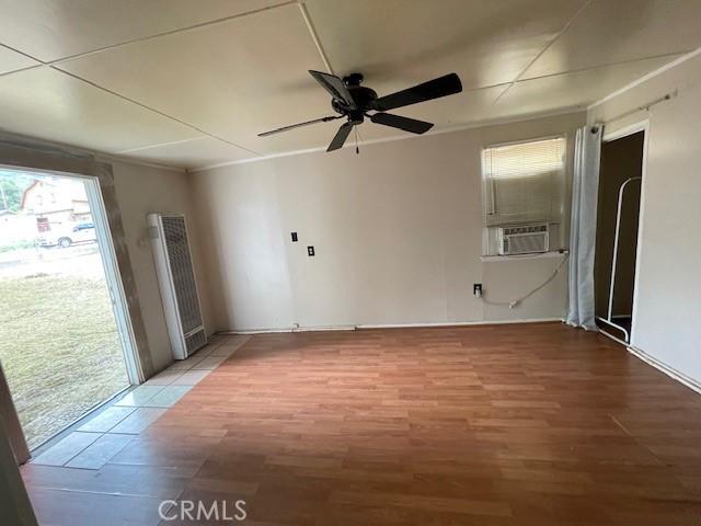 2968 Mill Creek Rd, Mentone, CA 92359 - empty room featuring a heating unit, a ceiling fan, light wood finished floors, and cooling unit