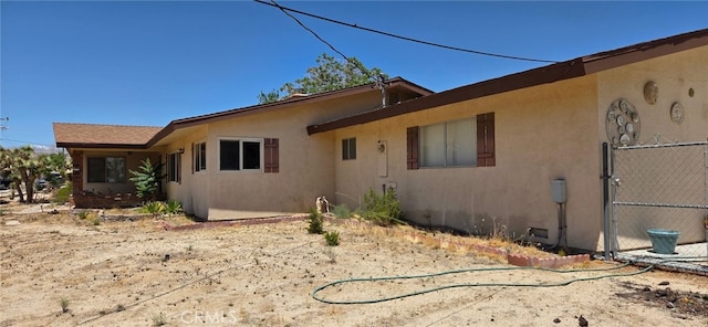 56994 Crestview Dr, Yucca Valley, CA 92284 - view of property exterior featuring stucco siding and a gate