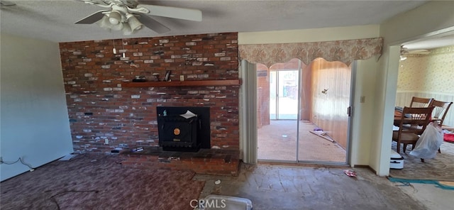 56994 Crestview Dr, Yucca Valley, CA 92284 - unfurnished living room featuring ceiling fan and a wood stove