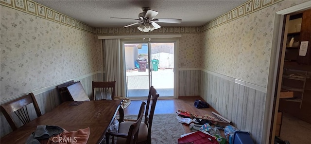 56994 Crestview Dr, Yucca Valley, CA 92284 - dining room featuring wallpapered walls, ceiling fan, a textured ceiling, wainscoting, and wood finished floors