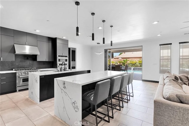 14258 Crow Rd, Apple Valley, CA 92307 - kitchen with an island with sink, under cabinet range hood, stainless steel range, open floor plan, and a sink