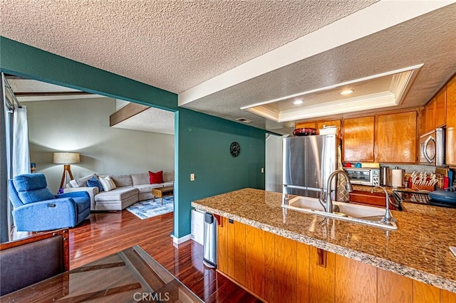 1130 Whitewater Dr Unit 263, Fullerton, CA 92833 - kitchen with a textured ceiling, a sink, brown cabinets, a raised ceiling, and a peninsula