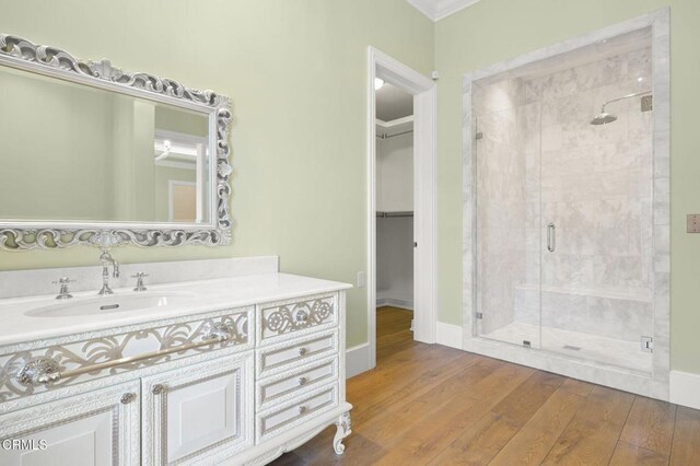 2112 Trentham Rd, Triunfo Pass-Point Mugu, CA 91361 - bathroom with a shower stall, vanity, a spacious closet, wood finished floors, and ornamental molding