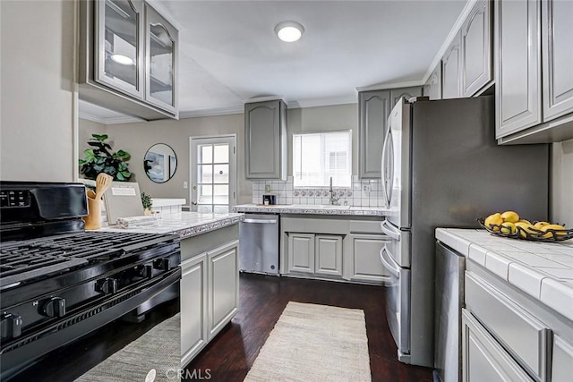 312 N Prospect Ave, Redondo Beach, CA 90277 - kitchen with appliances with stainless steel finishes, gray cabinets, decorative backsplash, dark wood-style floors, and ornamental molding