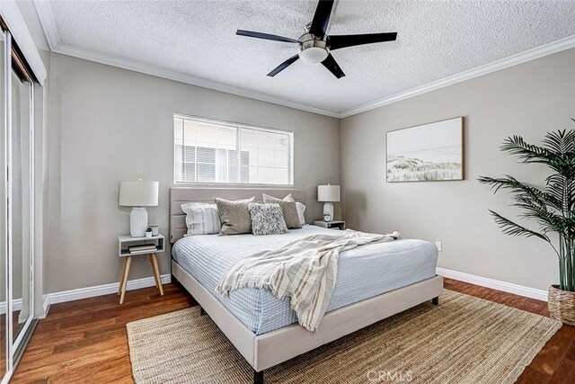 312 N Prospect Ave, Redondo Beach, CA 90277 - bedroom with wood finished floors, baseboards, a textured ceiling, crown molding, and a closet