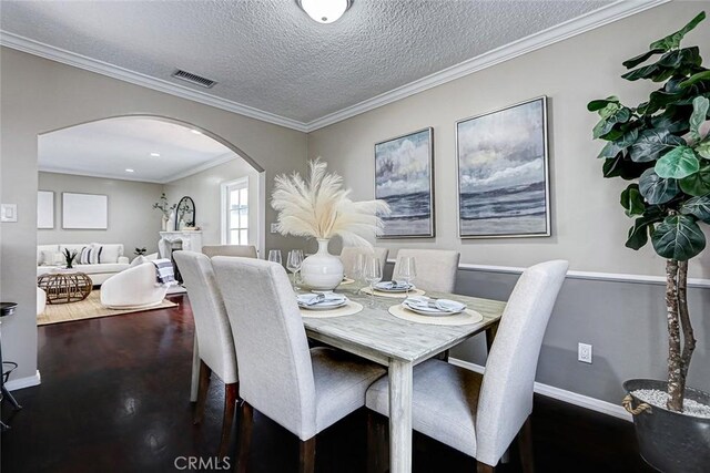 312 N Prospect Ave, Redondo Beach, CA 90277 - dining area featuring arched walkways, baseboards, wood finished floors, a textured ceiling, and crown molding