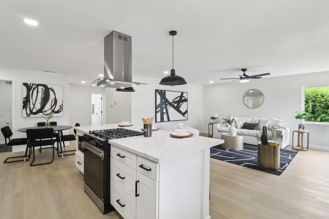 3243 Carolyn Cir, Oceanside, CA 92054 - kitchen with black gas range, island exhaust hood, light wood-style floors, white cabinetry, and a kitchen island