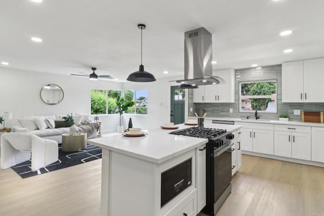 3243 Carolyn Cir, Oceanside, CA 92054 - kitchen featuring black range with gas cooktop, island range hood, light wood-style floors, healthy amount of natural light, and recessed lighting