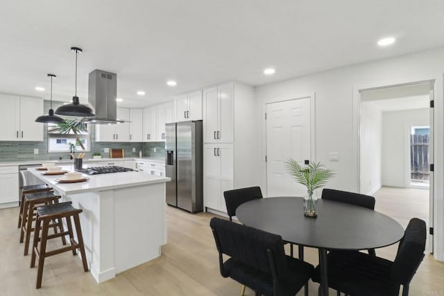 3243 Carolyn Cir, Oceanside, CA 92054 - kitchen featuring stainless steel appliances, island exhaust hood, light countertops, tasteful backsplash, and recessed lighting