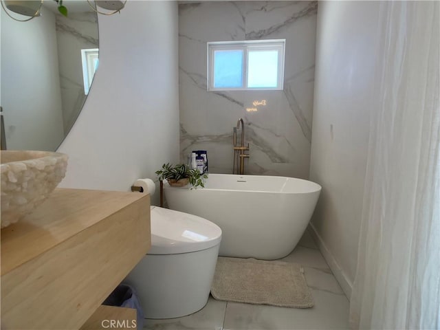622 S Highland Dr, Palm Springs, CA 92264 - bathroom with marble look tiles, a freestanding bath, and toilet