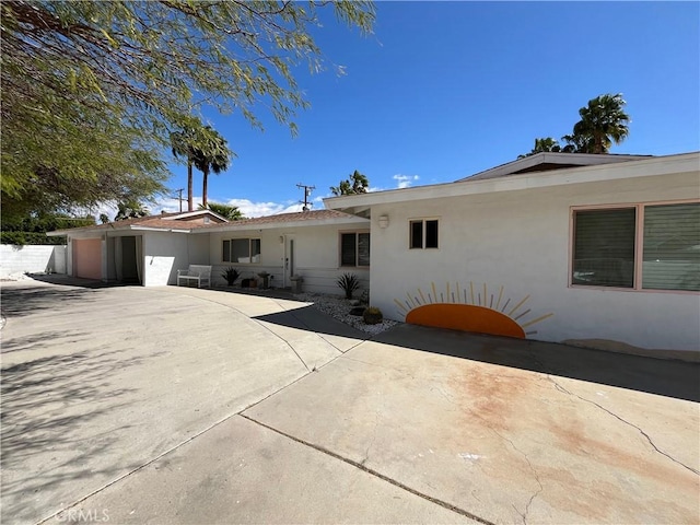 622 S Highland Dr, Palm Springs, CA 92264 - view of front facade with stucco siding, an attached garage, concrete driveway, and a patio area