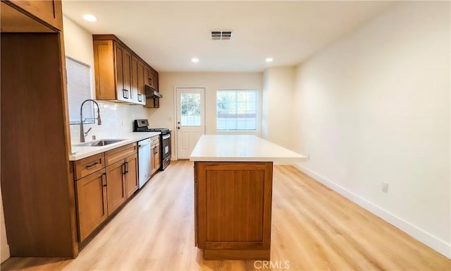 436 E Truslow Ave, Fullerton, CA 92832 - kitchen featuring a sink, stainless steel appliances, light wood-type flooring, a kitchen island, and decorative backsplash
