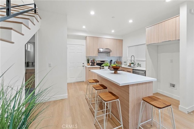 436 E Truslow Ave, Fullerton, CA 92832 - kitchen with modern cabinets, under cabinet range hood, a kitchen breakfast bar, light brown cabinetry, and recessed lighting