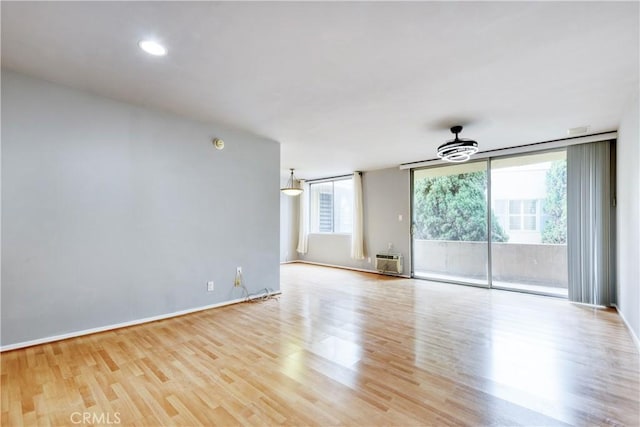 514 S Harvard Blvd Unit 309, Los Angeles, CA 90020 - unfurnished room featuring wood finished floors, an AC wall unit, and baseboards