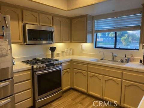 206 S Oak Glen Ave, Nipomo, CA 93444 - kitchen featuring appliances with stainless steel finishes, a sink, light wood-type flooring, and tile countertops