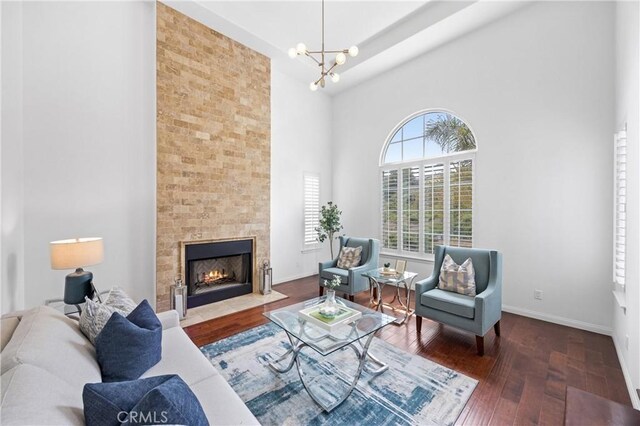 2421 N Feather Hill Dr, Orange, CA 92867 - living room with a high ceiling, wood-type flooring, a chandelier, a large fireplace, and baseboards