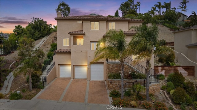 2421 N Feather Hill Dr, Orange, CA 92867 - mediterranean / spanish home with a tiled roof, stucco siding, a chimney, concrete driveway, and stairs