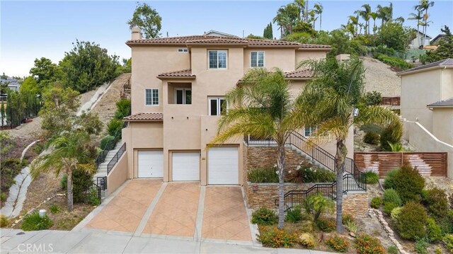 2421 N Feather Hill Dr, Orange, CA 92867 - mediterranean / spanish-style home with a tiled roof, a chimney, stucco siding, an attached garage, and concrete driveway