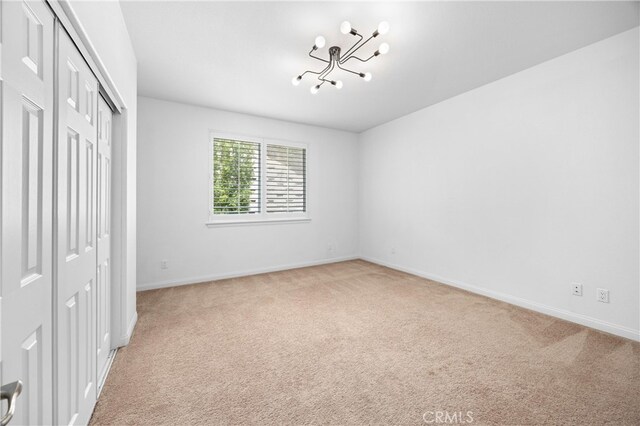 2421 N Feather Hill Dr, Orange, CA 92867 - unfurnished bedroom with a chandelier, light colored carpet, a closet, and baseboards