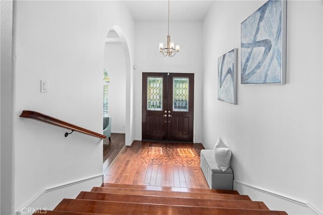2421 N Feather Hill Dr, Orange, CA 92867 - entryway featuring wood-type flooring, a chandelier, stairs, arched walkways, and french doors