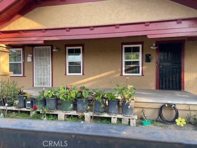714 E 2nd St, Santa Ana, CA 92701 - view of exterior entry featuring stucco siding and covered porch