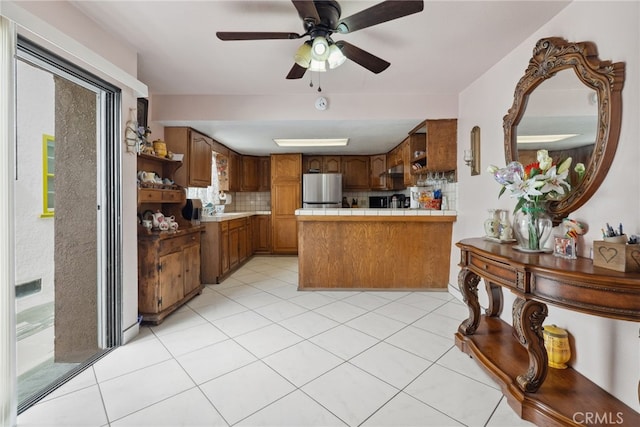 9637 San Carlos Ave, South Gate, CA 90280 - kitchen with open shelves, freestanding refrigerator, tasteful backsplash, a peninsula, and light tile patterned flooring