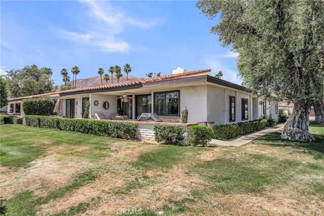 17 Toledo Dr, Rancho Mirage, CA 92270 - view of front of home featuring a front yard, stucco siding, a chimney, and a tile roof