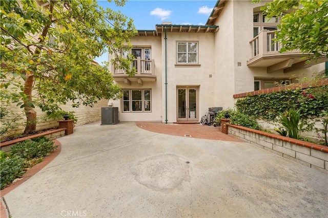 2517 Tequestra, Tustin, CA 92782 - rear view of house with french doors, a balcony, stucco siding, a patio area, and central AC