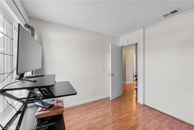 3611 Jupiter Ave, Palmdale, CA 93550 - home office with a textured ceiling, light wood-style floors, and baseboards