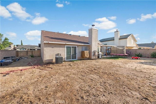 3611 Jupiter Ave, Palmdale, CA 93550 - back of property with a trampoline, cooling unit, a fenced backyard, and stucco siding