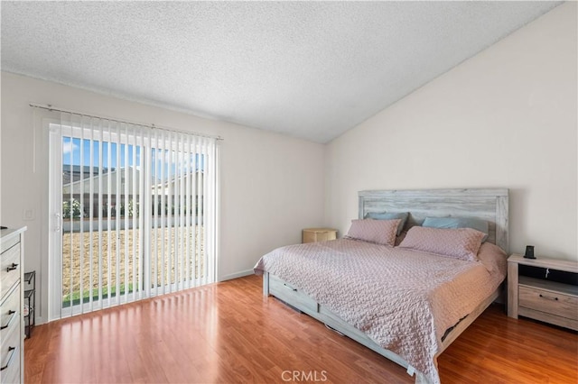 3611 Jupiter Ave, Palmdale, CA 93550 - bedroom with wood finished floors, a textured ceiling, vaulted ceiling, access to outside, and baseboards