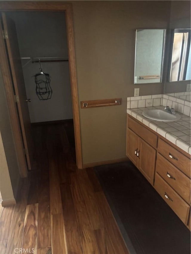 18515 Kalin Ranch Dr, Victorville, CA 92395 - bathroom with wood finished floors, vanity, baseboards, and backsplash