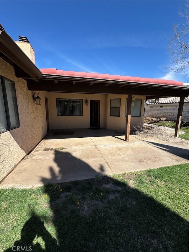 18515 Kalin Ranch Dr, Victorville, CA 92395 - rear view of house featuring a patio area, stucco siding, and a chimney