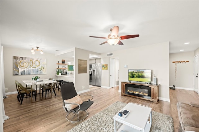 24311 Canyon Lake Dr N Unit 12, Canyon Lake, CA 92587 - living room featuring a ceiling fan, light wood-style flooring, baseboards, a glass covered fireplace, and recessed lighting