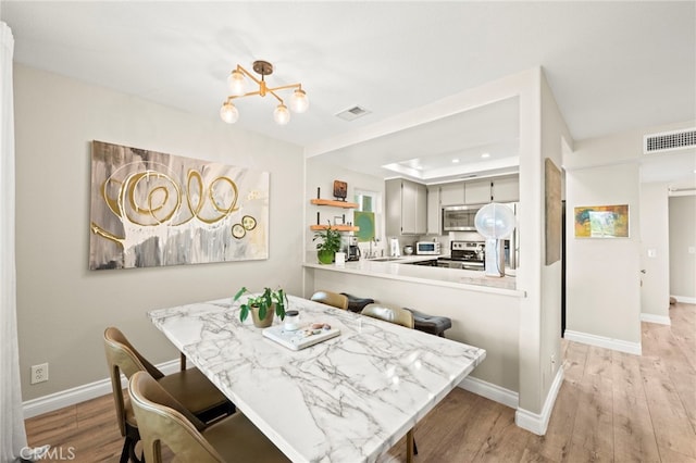 24311 Canyon Lake Dr N Unit 12, Canyon Lake, CA 92587 - dining area with a tray ceiling, light wood-type flooring, a chandelier, and baseboards