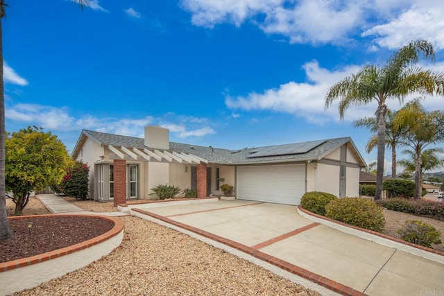 16182 Selva Dr, San Diego, CA 92128 - view of front of property featuring roof mounted solar panels, a garage, stucco siding, and driveway