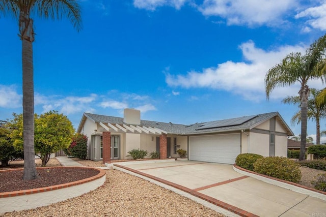 16182 Selva Dr, San Diego, CA 92128 - view of front facade with solar panels, an attached garage, concrete driveway, and stucco siding