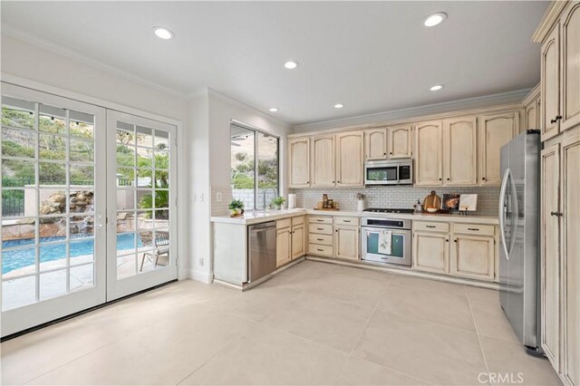 25605 Wordsworth Ln, Stevenson Ranch, CA 91381 - kitchen with stainless steel appliances, ornamental molding, light brown cabinetry, light countertops, and decorative backsplash