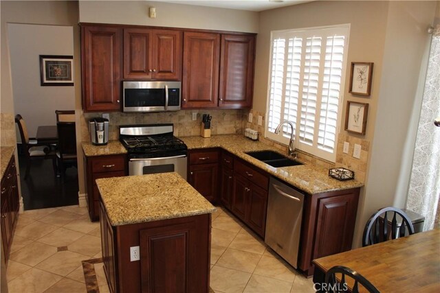 1338 Coral Gables Cir, Corona, CA 92881 - kitchen with appliances with stainless steel finishes, a sink, backsplash, light tile patterned floors, and light stone countertops
