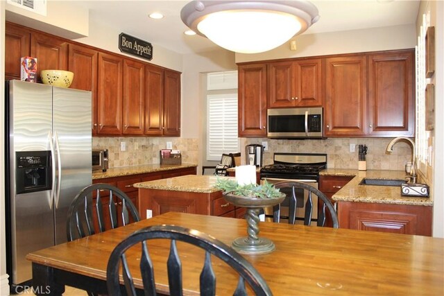 1338 Coral Gables Cir, Corona, CA 92881 - kitchen with appliances with stainless steel finishes, a sink, tasteful backsplash, light stone countertops, and recessed lighting