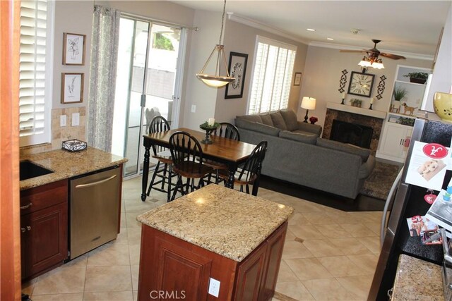 1338 Coral Gables Cir, Corona, CA 92881 - kitchen with dishwasher, a fireplace, ornamental molding, ceiling fan, and light tile patterned floors