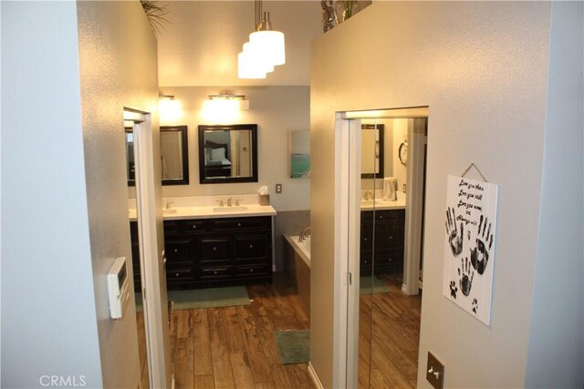 1338 Coral Gables Cir, Corona, CA 92881 - bathroom with hardwood / wood-style flooring, two vanities, a garden tub, and a towering ceiling