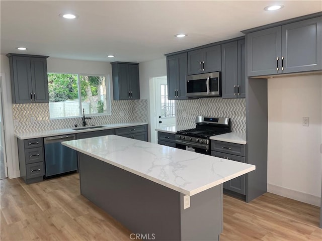 11431 Lee Ln, El Monte, CA 91731 - kitchen with stainless steel appliances, a sink, light stone counters, tasteful backsplash, and light wood-style flooring