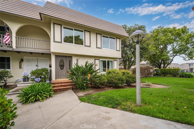 4057 Via Encinas, Cypress, CA 90630 - view of property featuring a balcony, stucco siding, and a front lawn