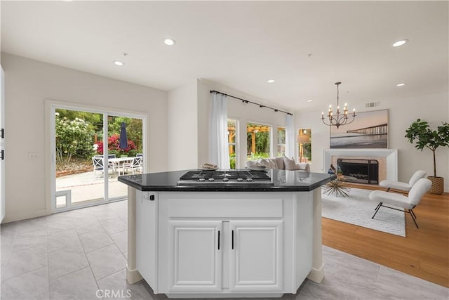 1641 Via Tulipan, San Clemente, CA 92673 - kitchen featuring stainless steel gas stovetop, plenty of natural light, white cabinetry, a fireplace, and recessed lighting