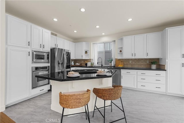 1641 Via Tulipan, San Clemente, CA 92673 - kitchen featuring appliances with stainless steel finishes, open shelves, a kitchen bar, white cabinetry, and a sink