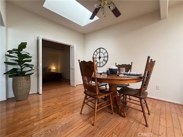 13721 El Dorado Dr Unit M3-K, Seal Beach, CA 90740 - dining room featuring a skylight, a ceiling fan, light wood-style floors, and baseboards