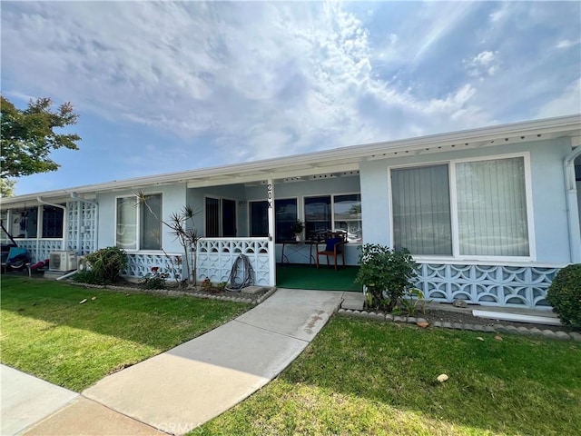 13721 El Dorado Dr Unit M3-K, Seal Beach, CA 90740 - view of front of property featuring covered porch, a front lawn, and stucco siding