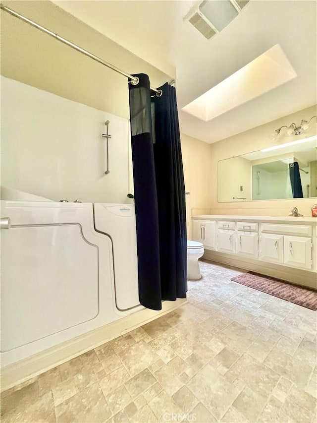 13721 El Dorado Dr Unit M3-K, Seal Beach, CA 90740 - bathroom with toilet, vanity, stone finish flooring, and a shower with shower curtain