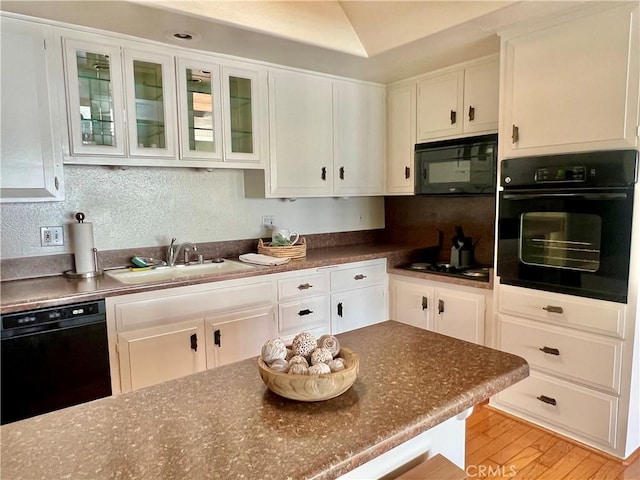 13721 El Dorado Dr Unit M3-K, Seal Beach, CA 90740 - kitchen featuring black appliances, a sink, white cabinets, dark countertops, and glass insert cabinets